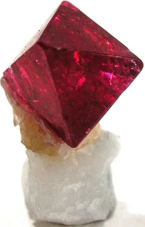 A red spinel crystal set in white calcite matrix